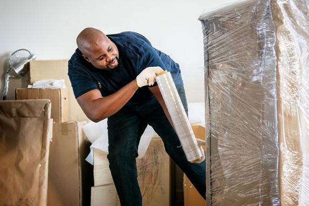 man wrapping item with stretch film